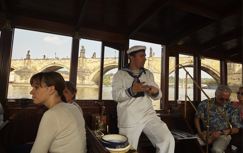 The ship's captain on the ship tells the history of the Charles Bridge